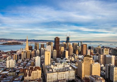 Skyscrapers in San Francisco with a glimpse of the bay behind them