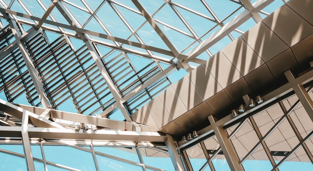 Intertwining metal pillars of an office building with glass windows in between