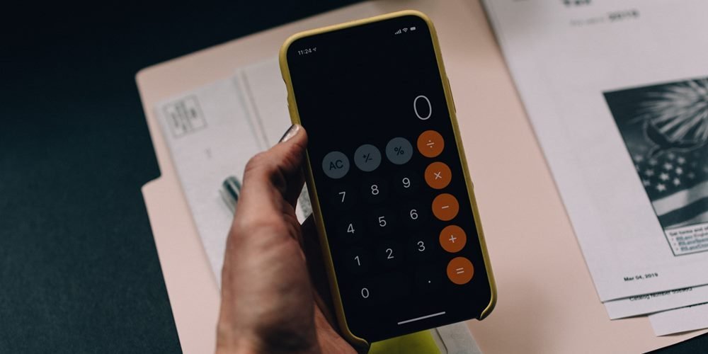 Man holding a phone with calculator opened