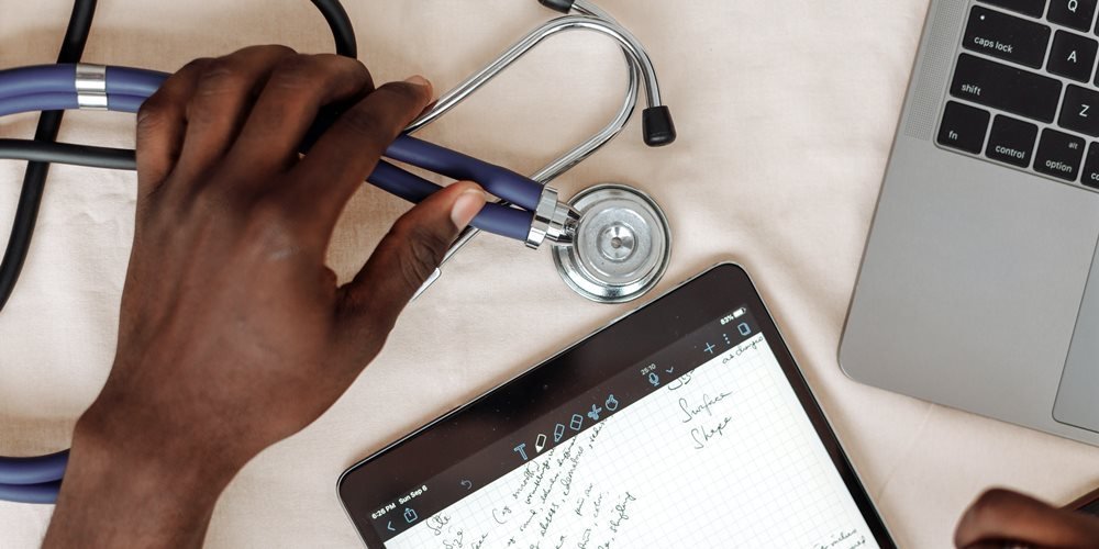 A doctor taking notes on a tablet