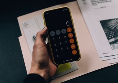 Man holding a phone with calculator app opened