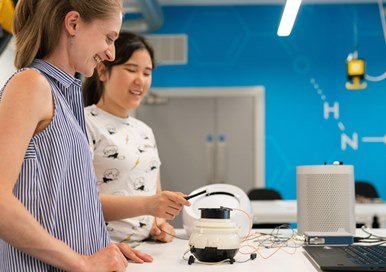 Two women testing a robot n a lab