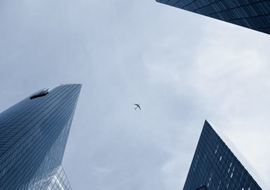 A plane on the sky between skyscrapers