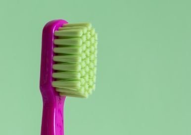 Pink toothbrush with green background