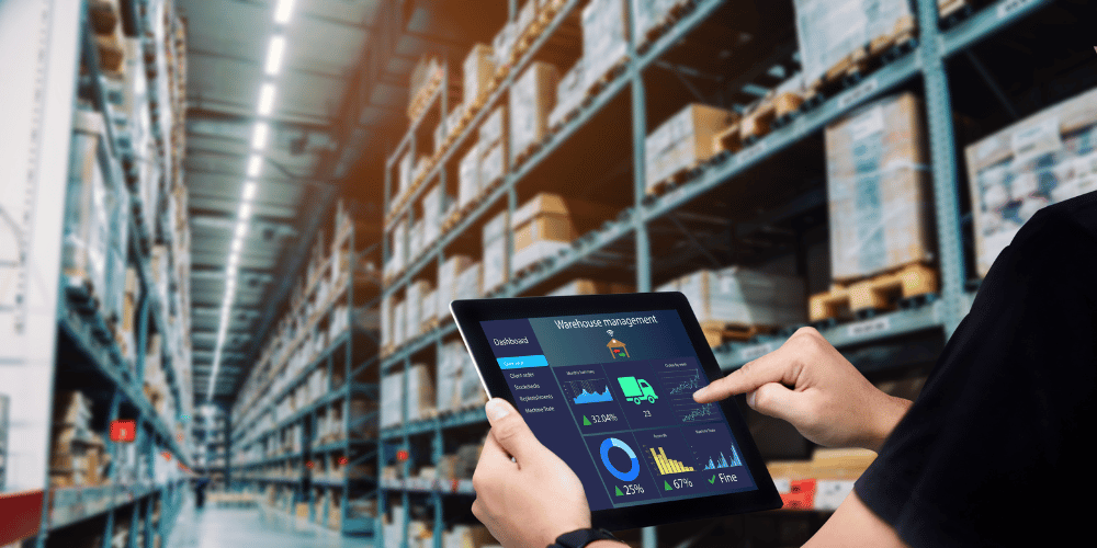 man in warehouse looking at a tablet with warehouse management application