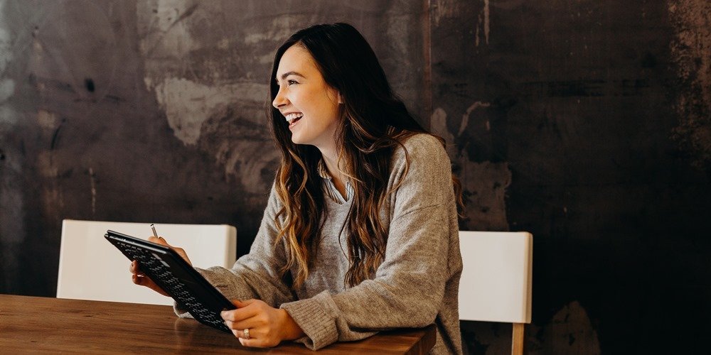 A women sitting, smiling