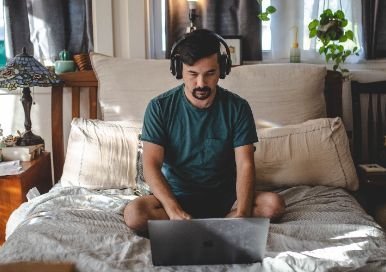 Man working from his bed at home